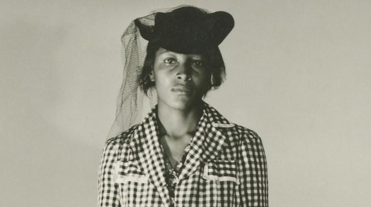 Recy Taylor wears a checkered blouse and a black hat with a veil