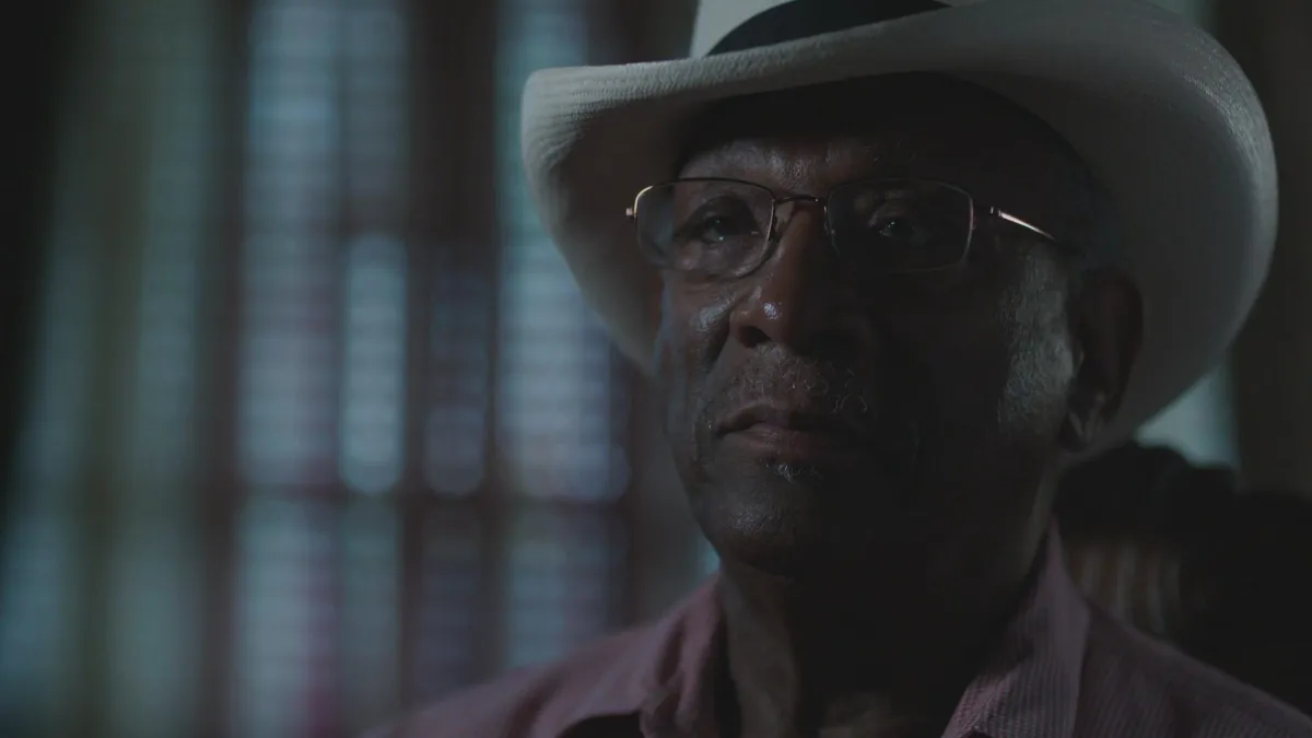 African-American man with a hat staring into the camera