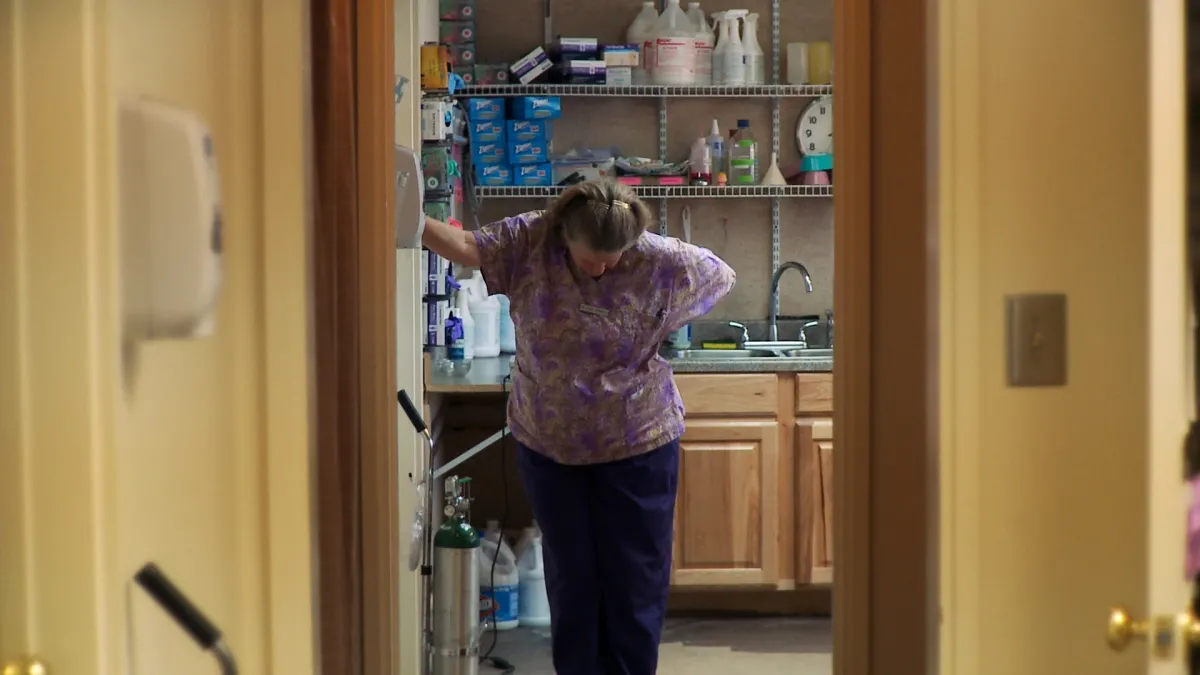 Kansas abortion doctor stands in office doorway looking down towards the ground