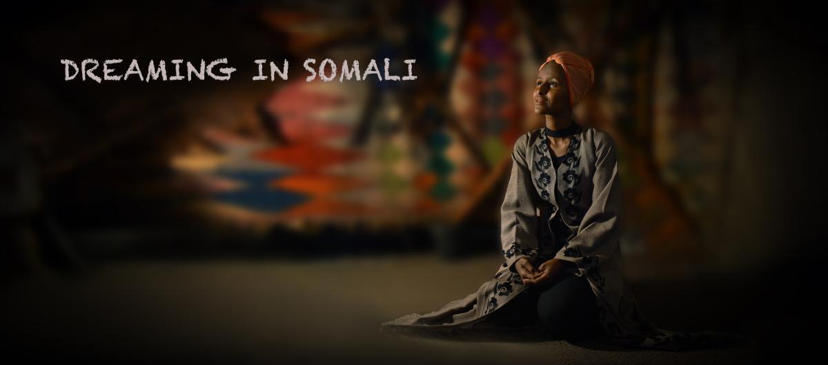 A female Somalian is sitting on the ground.