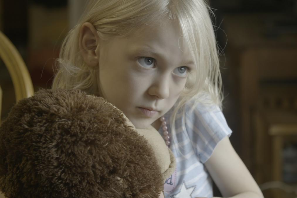 Transgender child and main subject of Mama Bears holding a stuffed toy.