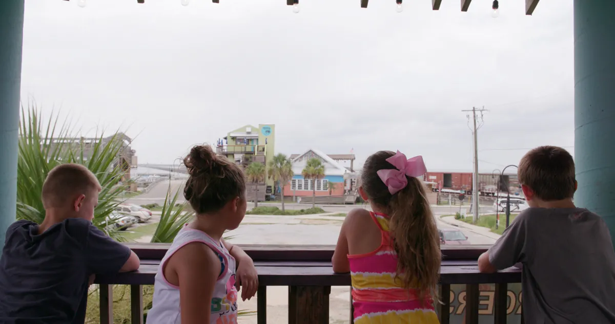 two young boys and two young girls stare away from camera looking onto a Mississippi street.