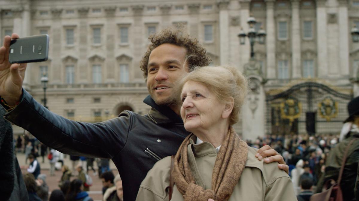 Sian-Pierre and his mom are taking a selfie in a European city.