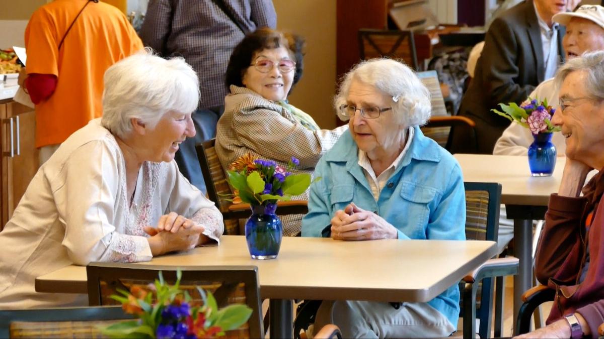 A group of senior citizen women sit and talk