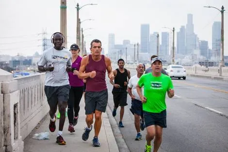 a group of men jog over a bridge in Downtown Los Angeles