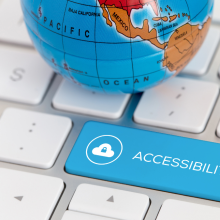 A globe sits on top of a computer keyboard with a blue key that reads "Accessibility"
