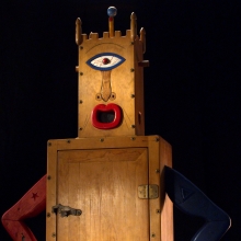 Still image from 'Westermann: Memorial to the Idea of Man If He Was an Idea,' depicting one of Westermann's wood sculptures against a black background.