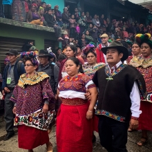 Juanita Alonzo Santizo, arm in arm with her aunt and uncle, Ana and Pedro, parading her in their colorful traditional ceremonial attire through the streets of their hometown San Mateo Ixtatán in Guatemala upon her return after over 7 years wrongfully detained. The whole town surrounds the family and the campaign team.
