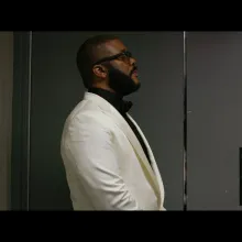 Tyler Perry film still in a white suite.