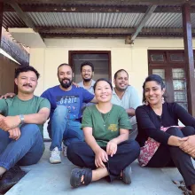 The Himalayan Story Lab Group photo outside of a yellow building with brown trim.