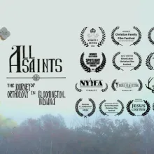 The background of this image is looking up to the sky and seeing the tops of trees at the bottom.  On the right half of the image is the title "All Saints: The Journey of Orthodoxy in Bloomington, Indiana" next to a Byzantine Cross. The left side has 13 film festival laurel images.
