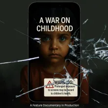 A child stares at the viewer through a cracked cell phone screen.
