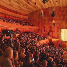 Wide shot of a grand auditorium filled with spectators.