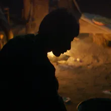 Silhouette of a man bent over.