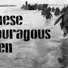 Black and white photograph of soldiers wading through the water on D-Day