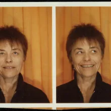 Two printed photos of a middle-aged white woman with short spiky auburn hair making two different expressions 