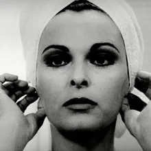 Black and white close-up of a beautiful white woman with lipstick as she adjusts the towel in her hair with her hands