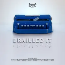 A blue Perkins brailler sits on a white backdrop. The film's title, Brailled It, is beneath the brailler in standard print and braille.