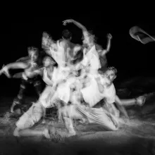 Juilliard dancers on the beach in a motion blur of gestures.