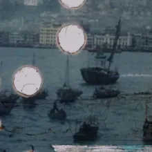 A blue image of ships in a bay is riddled with several small circular holes on the left half of the image, revealing a white background