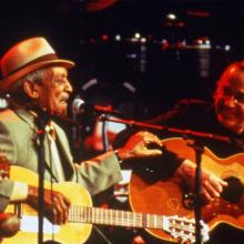 Two older men play guitar on stage, from Wim Wenders' 'Buena Vista Social Club.'