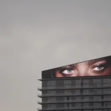 An image of a pair of eyes displayed on a screen atop a skyscraper. From Todd Chandler’s 'Bulletproof.' Courtesy of Grasshopper Film.