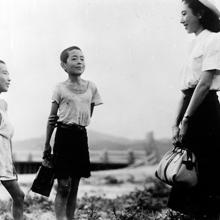 A Japanese woman talks with two young boys, from 'Children of Hiroshima.'