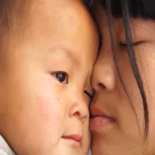 A close-up photo of Jin Zhou, a young Chinese woman, and her infant son Chenxi Huang. From Wang Qiong’s ‘All About My Sisters.’ Courtesy of the dGenerate Collection at Icarus Films.