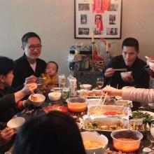 Filmmaker Hao Wu is a Chinese American male. Seen here sitting eating at a table with his child, his family members, and partner. From Hao Wu’s ‘All in My Family.’ Courtesy of Netflix.