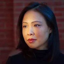Poh Si Teng is an Asian woman of Malaysian Chinese origin with shoulder-length black hair. She is wearing a black turtleneck & in front of a brick wall. Photo by Marcus Yam