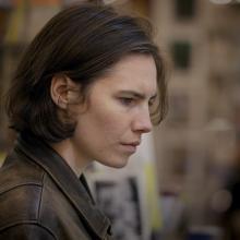 Side profile of Amanda Knox, a white woman with short brown hair. She is wearing a leather jacket. Image from from Ron Blackhurst and Brian McGinn's 2016 film ‘Amanda Knox.’ Courtesy of Netflix.