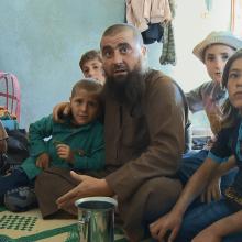 Abu Osama is a bald Syrian man with a beard, sitting with his children at his home in Syria. From Talal Derki’s Academy Award-nominated  ‘Of Fathers and Sons.’ Courtesy of Kino Lorber.