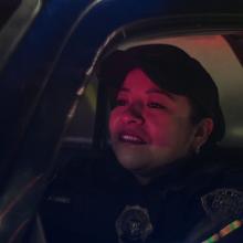 Monica Del Carmen is a Mexican woman dressed as a cop sitting in a police car. From Alonso Ruizpalacios’ ‘A Cop Movie.’ Courtesy of Netflix.