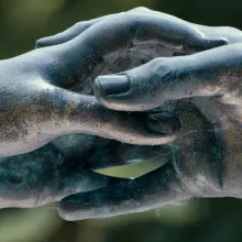 Detail from a black stone statue in Paris’ Père-Lachaise Cemetery, showing enclasped fingers of a figure. From Heddy Honigmann’s ‘Forever.’ Photo by Cobos Films, BV. Courtesy of Icarus Films. 