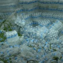 Hundreds of undistributed plastic bottles of water lying on the ground in Puerto Rico. Image from “Landfall,” directed by Cecilia Aldarondo. Photo by Pablo Alvarez-Mesa. Courtesy of POV