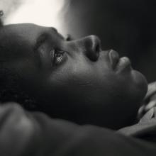 Mohammed Arif, a boy from Ethiopia, lies on his back with eyes looking up at the sky. Image from Jessica Beshir's 'Faya Dayi.' Courtesy of Cinetic Media. 