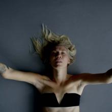 Kelsey Peterson is a white woman seen here lying on her back, wearing a black bandeau. From Peterson’s ‘Move Me.’ Courtesy of Full Frame Film Festival.