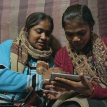 Meera and Shyamkali are two South Asian journalists looking at filmed footage on a cellphone. From Rintu Thomas and Sushmit Ghosh’s ‘Writing With Fire.’ Courtesy of Music Box Films