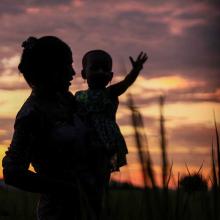 A silhouette of a woman holding a child against a sunset sky. From Hnin Ei Hlaing’s 'Midwives,' which recently played at Hot Docs. Courtesy of Hot Docs.