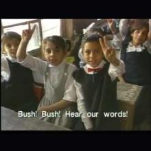 Kids on a bus hold up peace signs and chant 'Bush! Bush! Hear our words!' From Signe Taylor's 'Greetings from Iraq.'