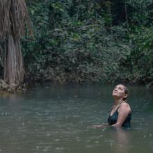 Neidinha Bandeira, an environmental activist, bathes in a river in the Amazon rainforest. From Alex Pritz’s ‘The Territory.’ Photo courtesy of National Geographic.