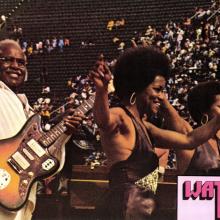 Pop Staples and the Staple Singers raise their hands to the audience after wowing the crowd at Wattstax.