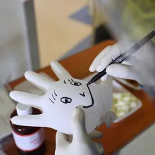 Someone is drawing a smiley face on a blown-up glove