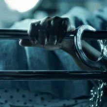close-up shot of a hand holding onto a hospital bed rail