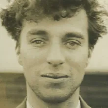 A sepia portrait of a white man with curly light hair.