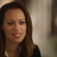 A Black woman with straight dark brown hair