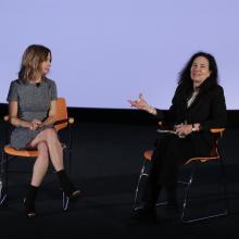 Caty Borum Chattoo (left) and Sally Jo Fifer (right) sitting on orange chairs next to each other.