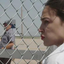 AOC looks through chainlink fence of detention center
