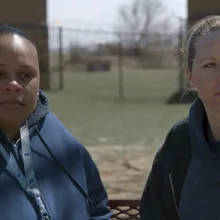 two incarcerated woman sitting on a bench