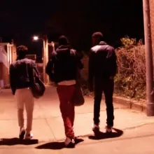 group of LGBTQ+ gang members walk down alley at night